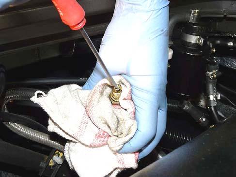 2.7 Carefully, wrap the fuel filter in a shop towel then, using a screwdriver, press gently on the pin inside the breather valve (W), until all pressure has been released from the fuel system (Fig.
