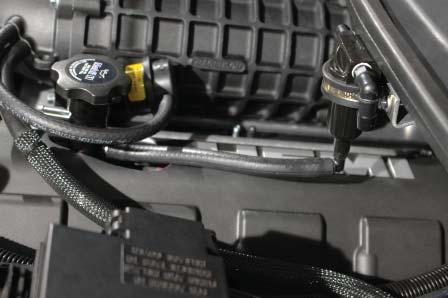 The embossed arrow on the top of the valve points toward the driver side fender.