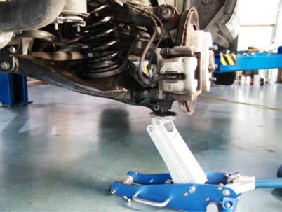 11. USING A FLOOR JACK, RAISE THE LOWER CONTROL ARM TO REALIGN WITH THE