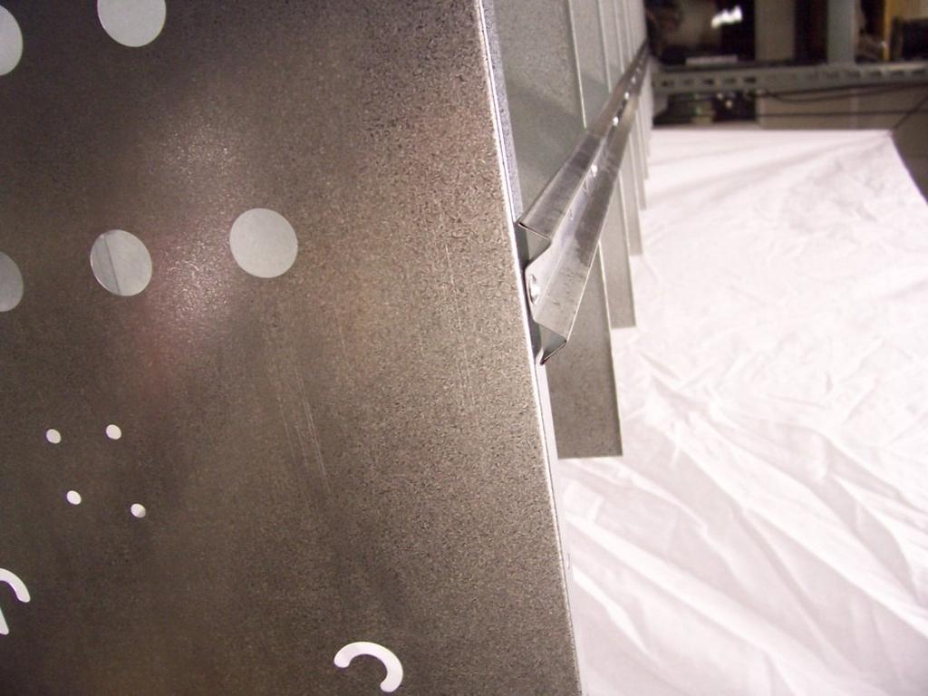 (SEE PHOTO ABOVE) After riveting partition brace to the partitions, slide assembly to edge of table so you can rivet