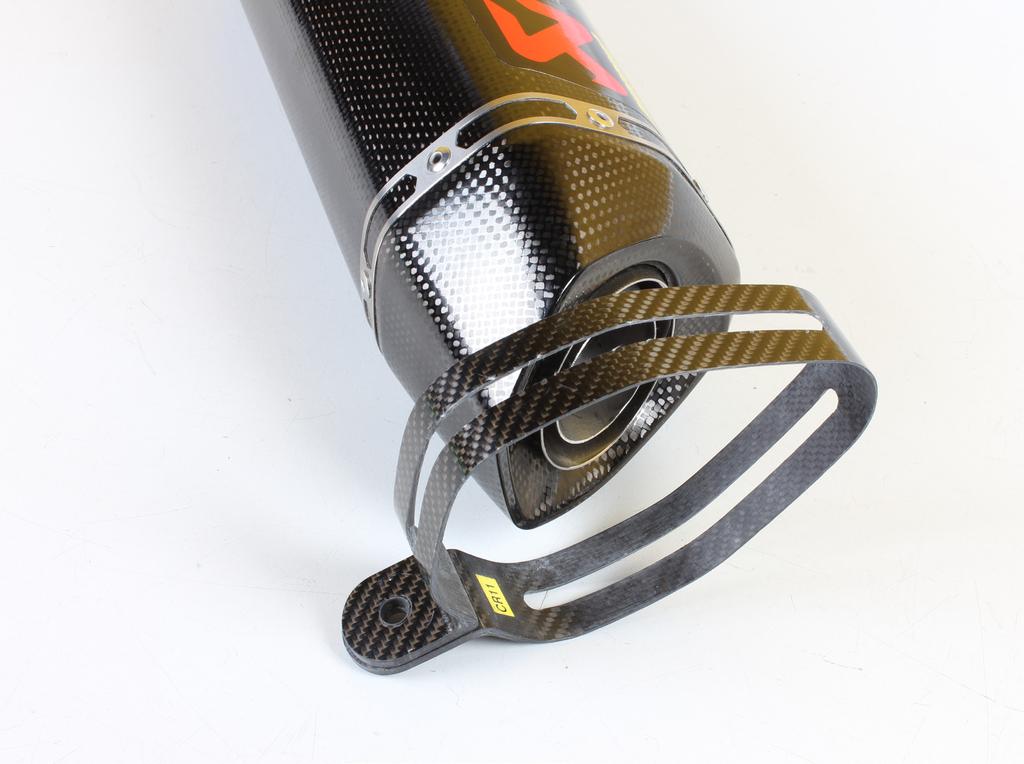 Correctly position the carbon-fiber clamp (check the position of the yellow sticker) and carefully slide it onto the muffler