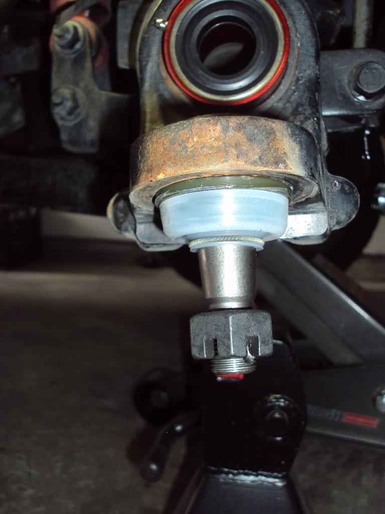 25) Install the dust boot on the lower ball joint by sliding it up the stud and