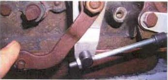 Reinstall the large washer and nut and two boots. Rotate the shift lever clockwise to the Park position.