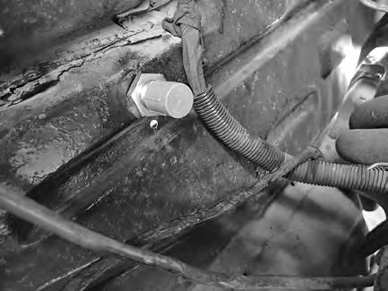 Locate the passenger side headlight wiring hole on the core support, and measure 1 ½ below the hole. Drill a 7/32 hole as shown in Photo 1, below. 2.