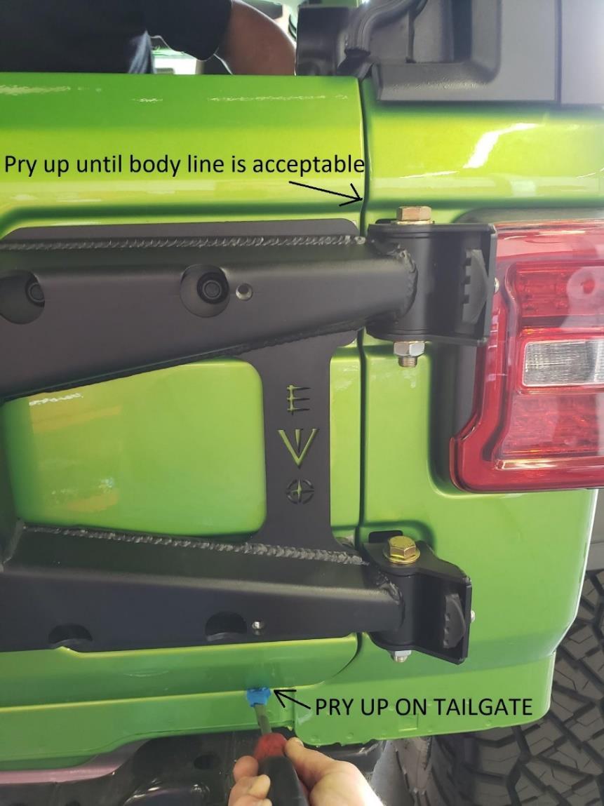 Using a flat head screw driver or small pry bar etc (apply protective tap on end to prevent scratching). Lift up on tailgate until the body lines are acceptable. 27.