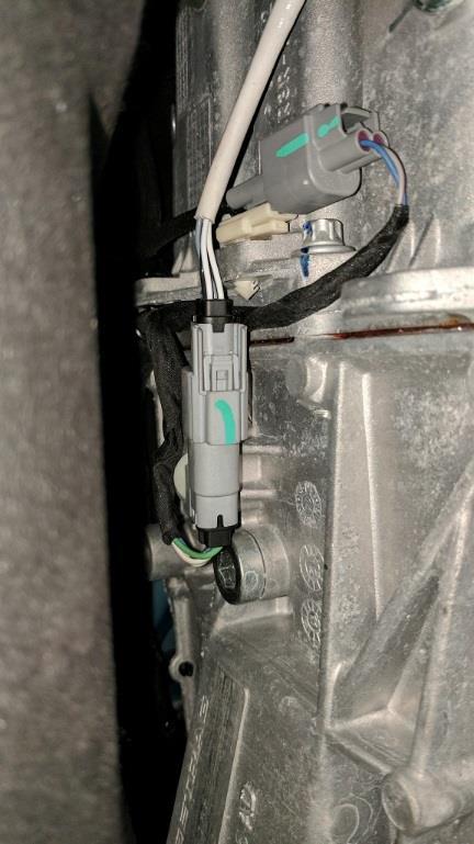 Driver Side: Remove the harness connector from the transmission and rotate it down so the connector is on the bottom side of the mounting point with the open end facing the rear of