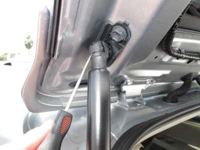 Using a hook tool pull out on retaining clips of the rear tailgate air struts.