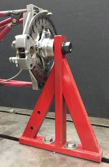 Figure 4: Rear end fixture, painted red in the photograph. The rear end fixture is bolted down to the bed plate with two 1 bolts to prevent translation.