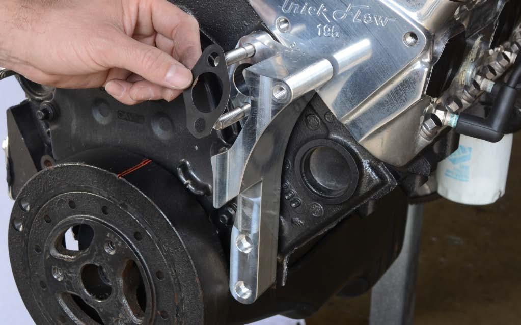 Apply a thin coat of RTV silicone sealer to both sides of two water pump gaskets and install one over the studs on the