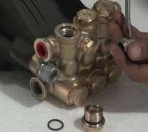 Start by inserting flat tip screw driver through the spring retainer just above the valve and press to create small gap between the