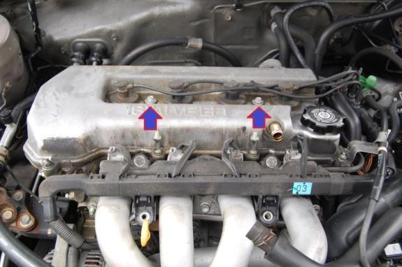 And lastly loosen the two bolts on the top. They are not removed, just loosened. Take a rubber mallet and gently tap on the valve cover to break the seal.
