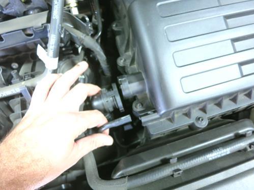 Remove the plastic engine cover by pulling up gently, releasing it from the rubber grommets. b. Loosen the hose clamp at the turbocharger and disengage the intake hose from the turbo inlet.