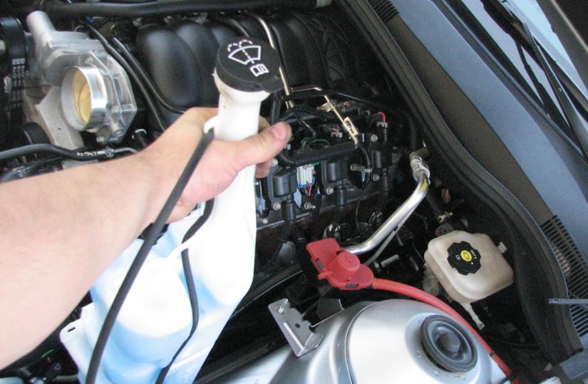 Unclip the washer hose from any retaining clips on the vehicle and remove the bottle as shown in Figure 5.