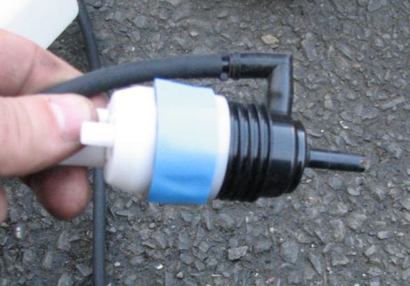 Figure 8: Tape applied to washer motor 14. Insert the factory grommet into the SLP washer bottle for the motor to sit in. Peel off the tape backing, and insert the motor into the SLP washer bottle.