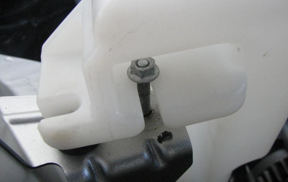 Be careful to not knock off the small clear bumper installed at the bottom of the washer bottle. See Figure 13.