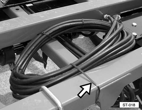 Neatly route the hydraulic hoses through the hose guides and along the tongue rail towards the front of the implement. Install the outer clamps and bolts and tighten the bolts.