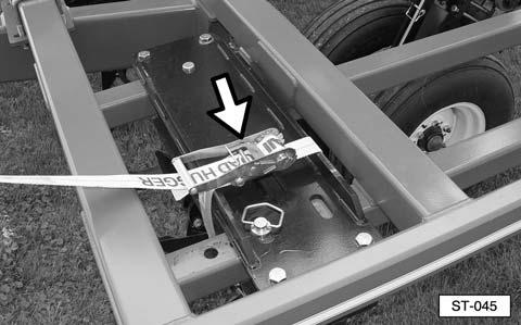 Install a ratchet strap or chain with a minimum 500 lb (227 kg) load rating securely around the tine gang shaft and upper carriage plate, as shown. NOTE: Model ST101 shown. Other models are similar.
