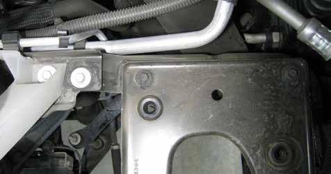 Remove the two bolts located next to the coolant reservoir leg, and the two bolts on top of the bracket as shown in Figure 4.