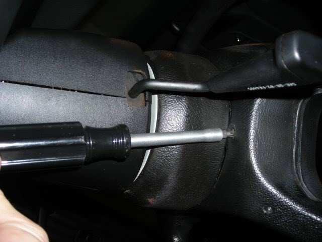 There are two screws on the back of the steering wheel at 3 o'clock and 9 o'clock. Disconnect the orange plug from the airbag and set aside.