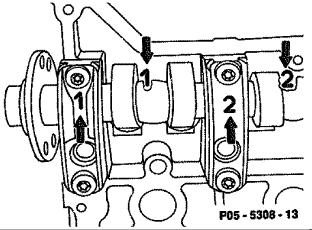 flanges (arrows). The camshaft bearing caps are identified with numbers (arrows).