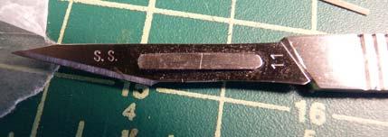then came back with the surgical blade. The wood is only 1/32" thick, so you only need a few light cuts to go through.