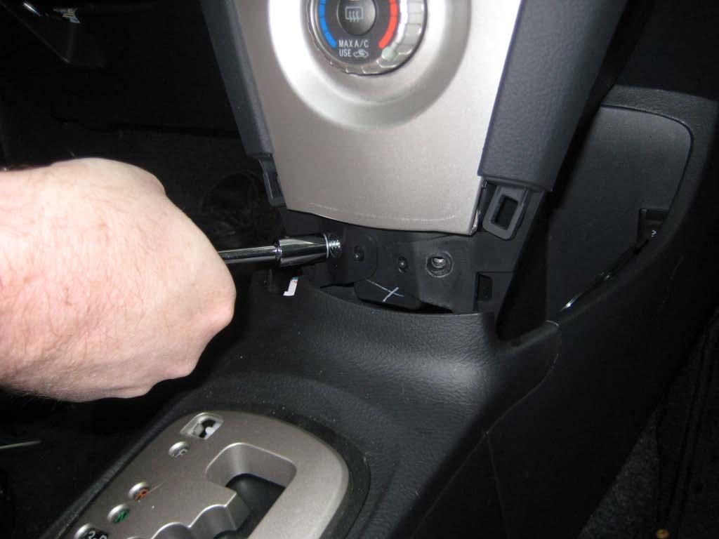 Use hands or a plastic panel removal tool to disengage the left and right center cluster side