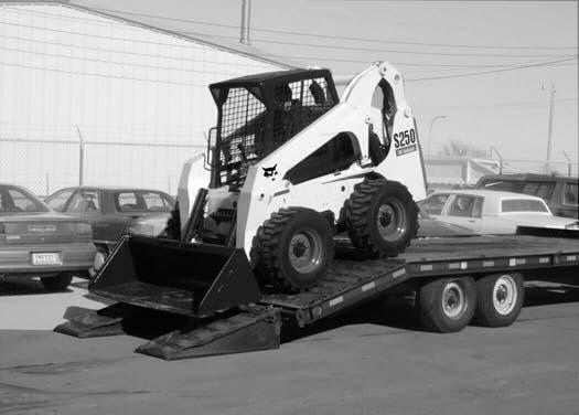 TRANSPORTING THE LOADER ON A TRAILER Loading And Unloading Fastening Figure 10-40-2 WARNING AVOID SERIOUS INJURY OR DEATH