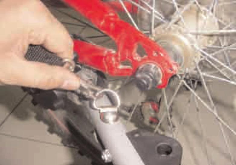 11). Tighten axle nut securely, testing to see the hitch is unable to pull loose (Fig. 12). Loop Safety Strap around frame and secure to D-ring on hitch arm (Fig. 13).