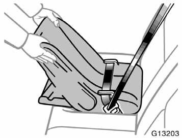 3. While pressing the infant seat firmly against the seat cushion and seatback, let the shoulder belt retract as far as it will go