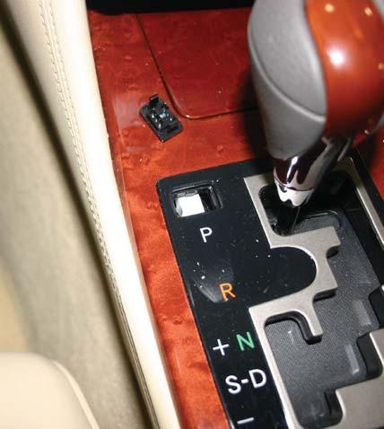 This is accomplished by lifting out the small cover to the left of the shifter Park (P) indicator and depressing the