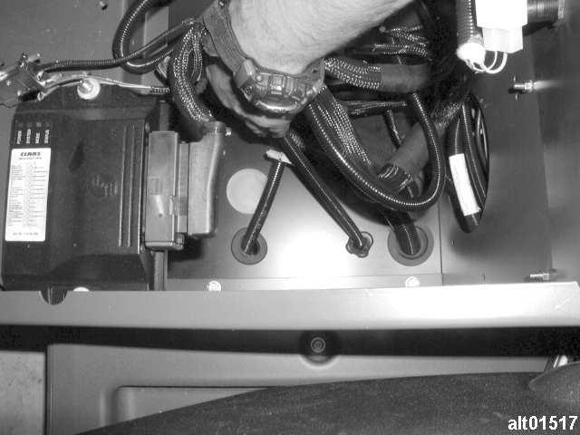 6. Cab cable should enter through back right side of console. Route cable forward through divider wall in console. 7. Remove grommet from hole in floor as shown in Figure 4.