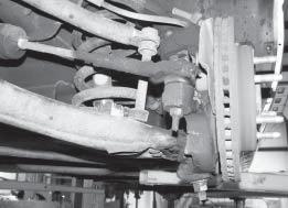 4 FIG. 3 10. Working on one side at a time, support the lower control arm with a hydraulic jack. Disconnect the upper and lower shock mounts and remove the shock from the vehicle.