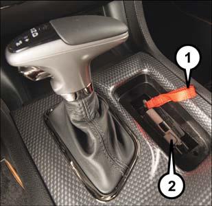 5. Press and maintain firm pressure on the brake pedal. 6. Insert the screwdriver into the slot in the center of the lever, and disengage the lever locking tab by pushing it to the right.