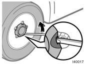 Blocking the wheel Removing wheel ornament Loosening wheel nuts 2. Block the wheel diagonally opposite the flat tire to keep the vehicle from rolling when it is jacked up.
