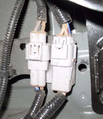 c. Remove clip and wire harnesses from bed of truck on