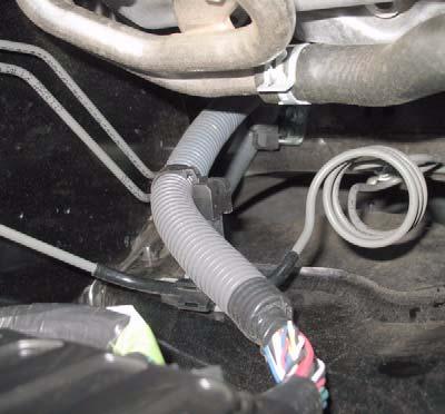 b. Remove two clips from harness at back of air box.