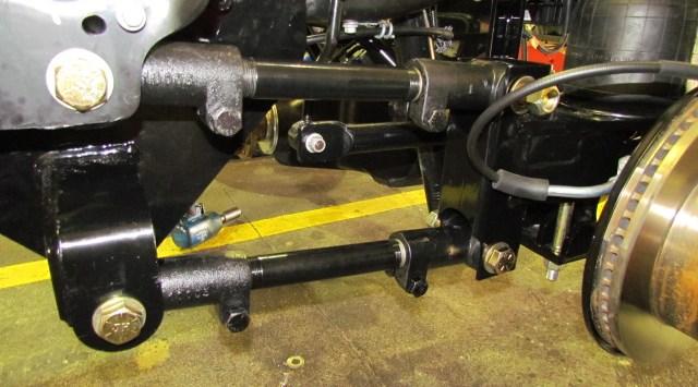 14. Locate the trailing arms (part # 10016). The front of the upper trailing arm goes into the original leaf spring perch. Use the 7/8 x 9 1/2 bolt to fasten in place.