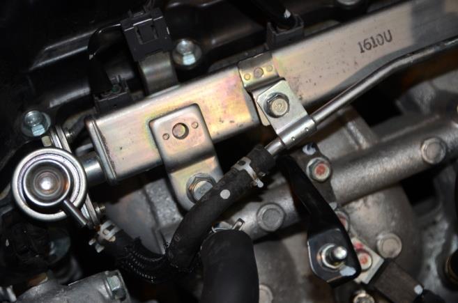 Loosen the spring clamp and disconnect the fuel return hose from