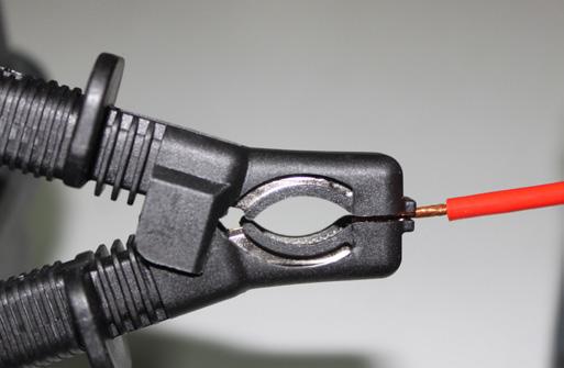 The system must be safely discharged before touching connections. Megger clip being tested with IEC standard test finger for creepage and clearance.