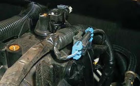 59. Disconnect the engine knock sensor connector and steel-mounting clip from the intake manifold by