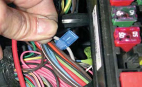 141. In the wiring below the fuse/relay center, locate the gray fuel pump wire that goes from the relay