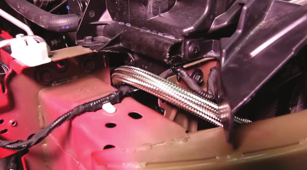 28. Take the longer of the two oil lines and connect it to the 34. Locate the supplied heat wrap and cut it in half lengthwise. driver-side port on the oil cooler, but do not fully tighten.