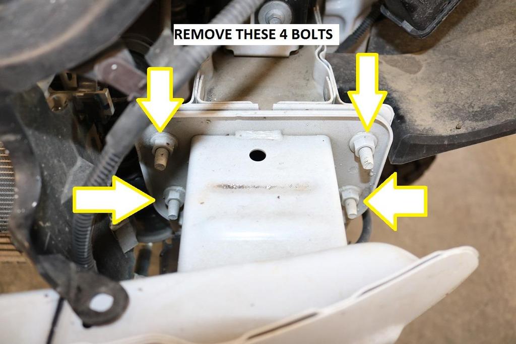 20) Once the cut has been made, use a 13mm socket / wrench and remove the 4 bolts securing the front bumper to the chassis. a. Note, a long extension (9-12 ) is helpful in reaching the inner bolts.