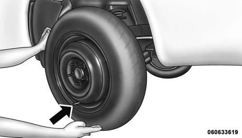 Mounting Spare Tire WARNING! To avoid the risk of forcing the vehicle off the jack, do not tighten the wheel nuts fully until the vehicle has been lowered.