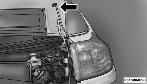 2. Move to the outside of the vehicle, reach into the opening beneath the center of the hood and push the safety latch lever to the right to release it, before raising the hood.