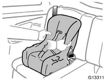 3. While pressing the convertible seat firmly against the seat cushion and seatback, let the shoulder belt retract as far as it will