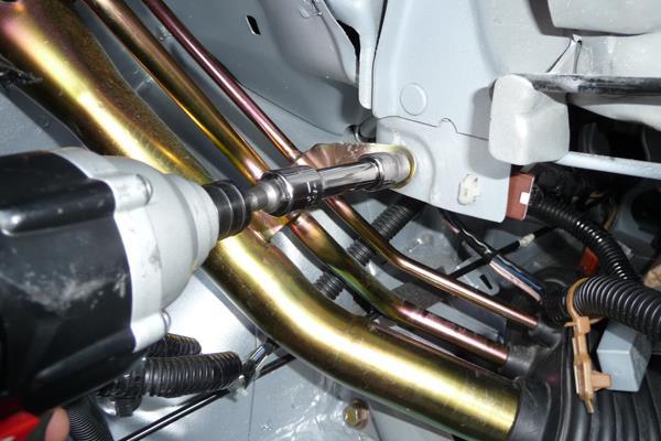 To release the gas filler tubes from the chassis, use a 10mm socket wrench to remove the M6 bolt shown.