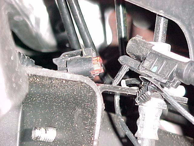 4. DISCONNECT THE ANTILOCK BRAKE WIRE FROM THE CONNECTOR LOCATED BEHIND THE UPPER CONTROL ARM MOUNTING POCKET. ANTILOCK WIRE CONNECTOR BEING DISCONNECTED.