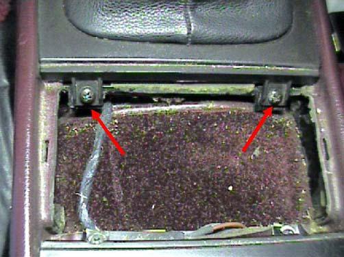 Open the lid on the ash tray stick your fingers down inside and pull straight up. It will pull right out of the console. a. Remove the two Phillips head screws at the front of the ash tray opening. b.