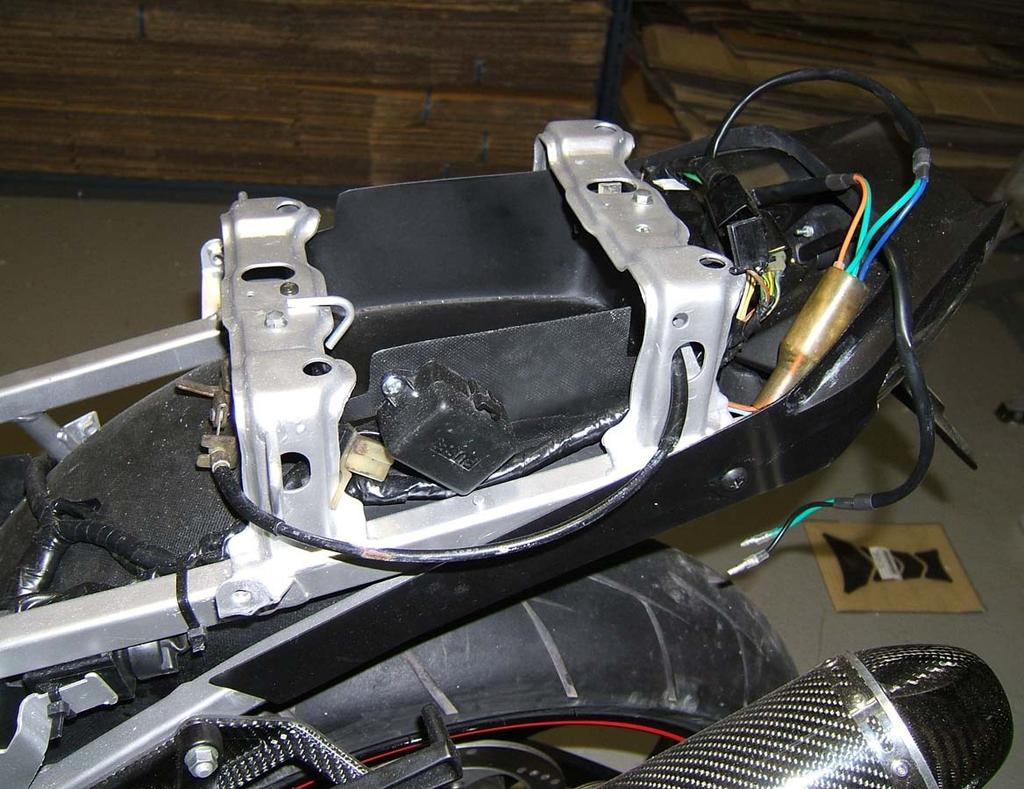 Disconnect all electrical components such as CDI, regulator and fuse box as well as the luggage hooks at the rear on the left and right.